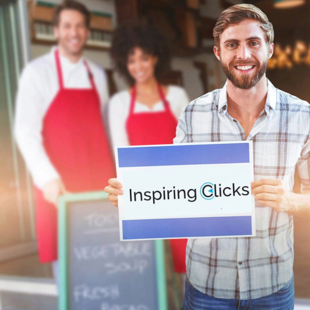 How important is content writing for seo? Happy business owner holding up an Inspiring Clicks sign after SEO content writing services helps rank his website on Google. Workers in the background smiling.