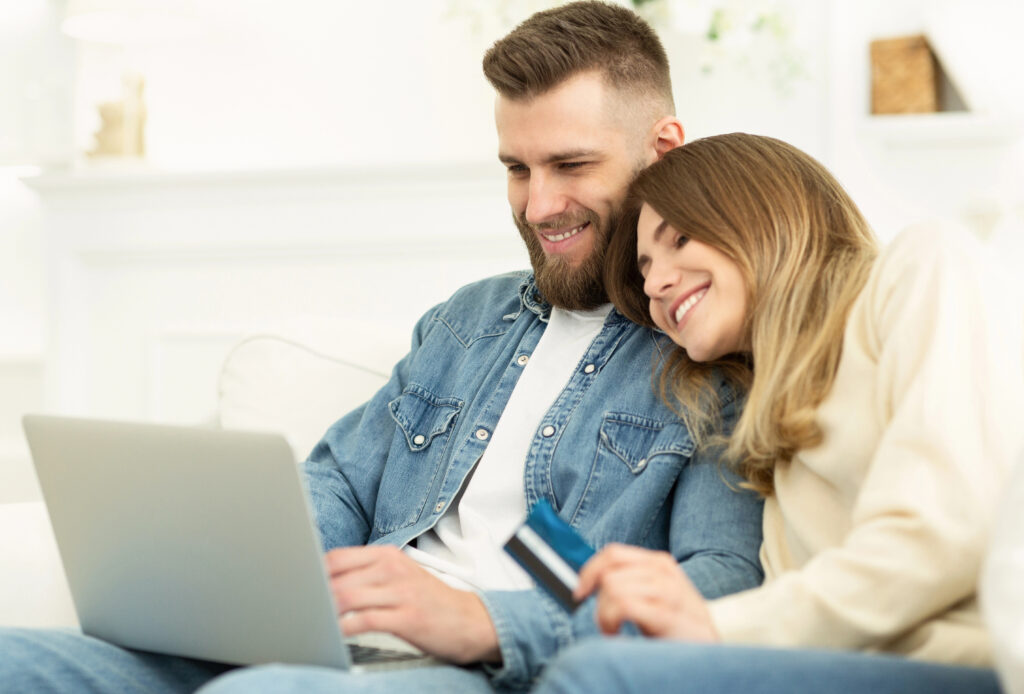 Couple about to make purchase on their laptop. InspiringClicks' creative writing services can help influence purchase decisions