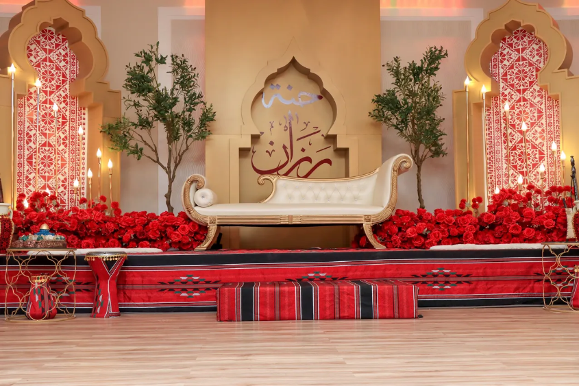 Cultural ceremony stage at Heritage Banquet Hall with red draping, ornamental arch, and cherry blossom tree decor